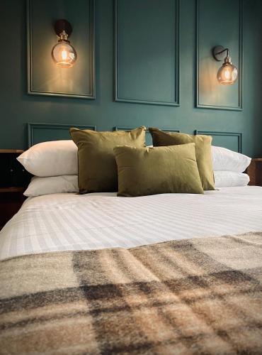 a bedroom with a large bed with green walls at Lochside Guest House in Arrochar