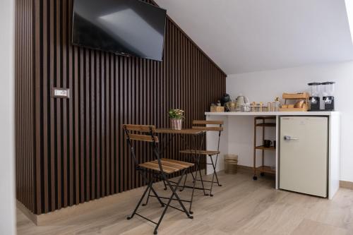 a kitchen with a counter and a table and chairs at Coraline Deluxe Rooms in Castellammare di Stabia