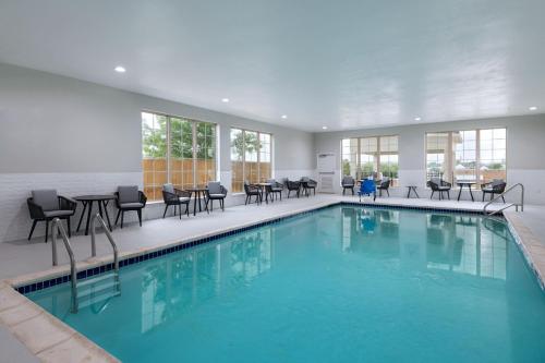 a swimming pool with chairs and tables in a building at TownePlace Suites by Marriott Weatherford in Weatherford