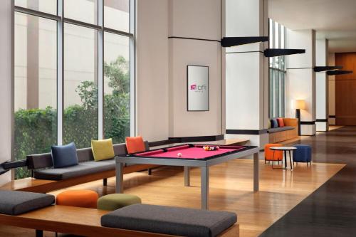 a room with a ping pong table and chairs at Aloft South Jakarta in Jakarta