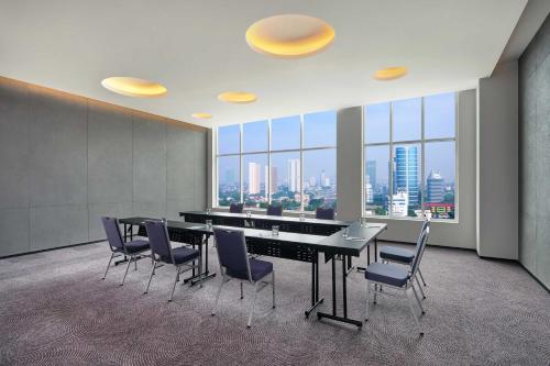 a conference room with a table and chairs and a large window at Aloft South Jakarta in Jakarta