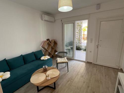 a living room with a blue couch and a table at Perla 2 Paralia Ofriniou in Ofrínion