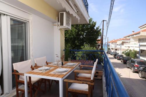 un tavolo e delle sedie sul balcone di un palazzo di MainAvenue Palm Seaside a Polykhrono