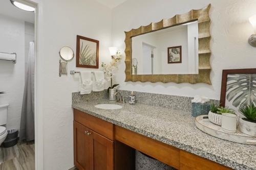 a bathroom with a sink and a mirror at Kahaki Hale in Kapaa