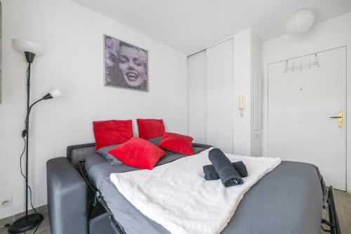 une chambre avec un lit avec des oreillers rouges dans l'établissement Studio Athéna, à Nice