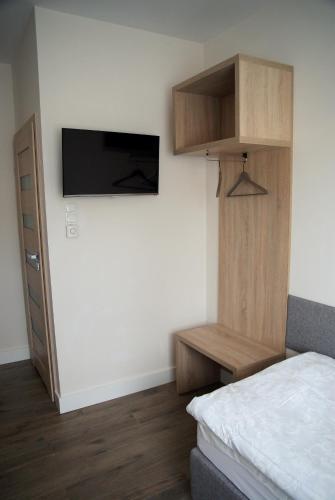 a bedroom with a bed and a tv on a wall at Willa Wiosna in Września