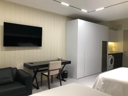 a room with a table and a chair and a television at Subang Jaya Armani Soho in Subang Jaya