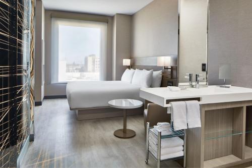 um quarto de hotel com uma cama e um lavatório em AC Hotel by Marriott Sacramento em Sacramento