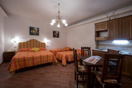 a bedroom with two beds and a table and a kitchen at Cecco di Nara in Massarosa