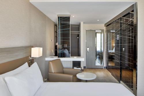 une chambre d'hôtel avec un lit et un salon dans l'établissement AC Hotel by Marriott Sacramento, à Sacramento