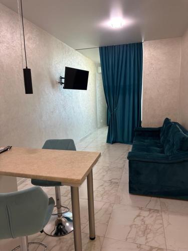 a living room with a table and a couch at Arcadia Adelina in Odesa