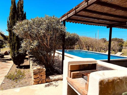 a swimming pool in front of a house with a tree at Casa Clot III- Formentera in Illes Balears