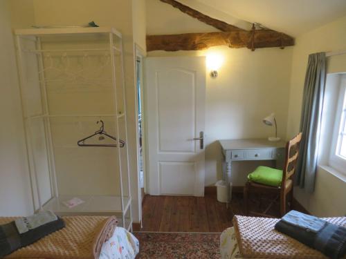 una stanza con una scrivania e un armadio e una stanza con una sedia di La Maison de Riviere a Bourg-Charente