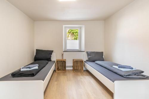 two beds in a room with a window at Große Wohnung zu mieten im schönen Sulzheim Wörrstadt in Sulzheim