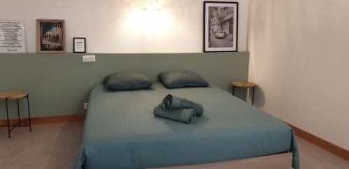 a bed with a bag sitting on top of it at La Maison Emilie in Villeneuve-dʼAveyron