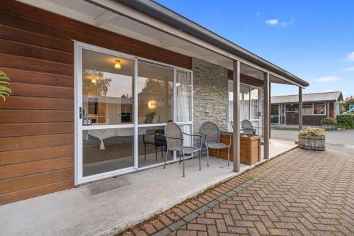 a screened in porch with chairs and a table at Tasman Holiday Parks - Te Anau in Te Anau