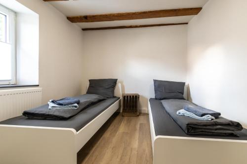 two twin beds in a room with a window at Große Wohnung zu mieten im schönen Sulzheim Wörrstadt in Sulzheim