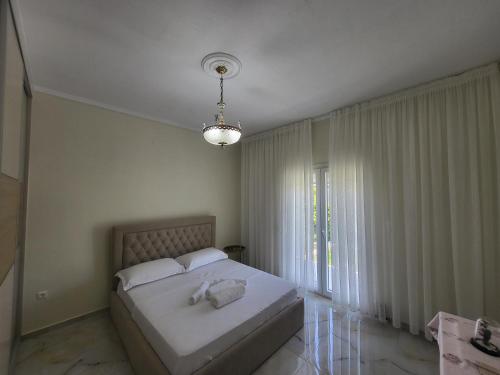 a bedroom with a bed and a large window at Villa Ndoni in Berat