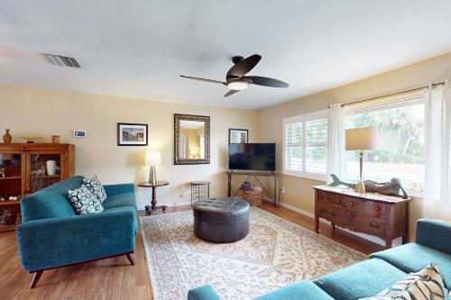 a living room with two blue chairs and a flat screen tv at Mermaid Shores in Sarasota