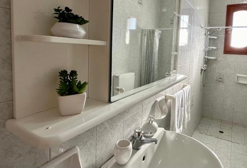 ein weißes Badezimmer mit Waschbecken und Spiegel in der Unterkunft Dimora Sammartino in Alliste