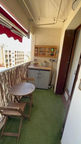 un balcon avec une table et des chaises et une cuisine dans l'établissement Appartement Marseille 5ème avec terrasse, à Marseille