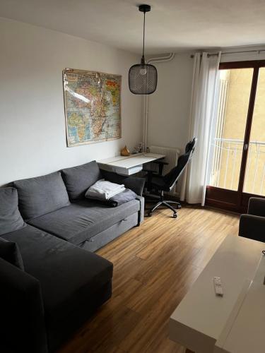 un salon avec un canapé et un bureau dans l'établissement Appartement Marseille 5ème avec terrasse, à Marseille