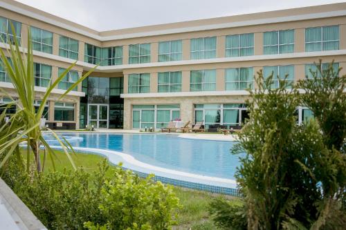 a large building with a swimming pool in front of it at Howard Johnson Neuquen in Neuquén