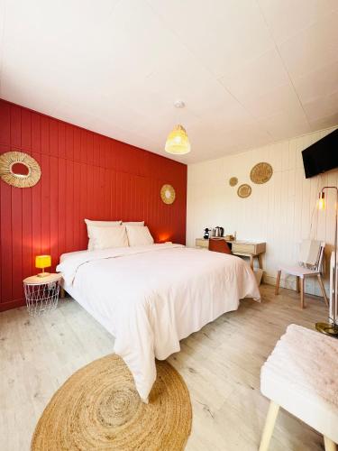 - une chambre avec un grand lit blanc et un mur rouge dans l'établissement Motel Les Broussailles, à Mesves-sur-Loire