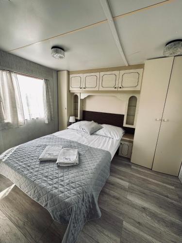 a bedroom with a large bed with two towels on it at Domki Parkowy in Kudowa-Zdrój