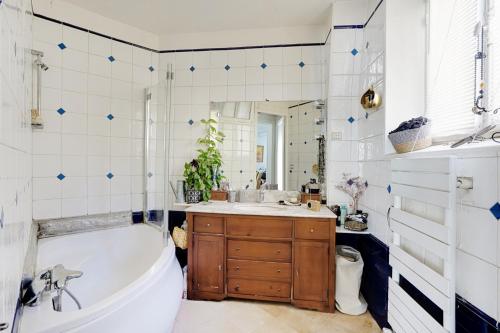 une salle de bain avec une baignoire et un lavabo dans l'établissement Appartement familial avec vue - République, à Paris