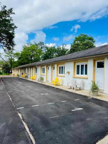 une rangée de bâtiments avec des chaises jaunes dans une rue dans l'établissement Motel Les Broussailles, à Mesves-sur-Loire