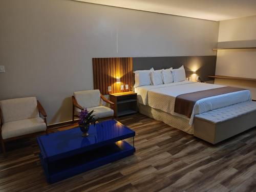 Habitación de hotel con cama, silla y mesa en Hotel Reserva do Xingó en Piranhas
