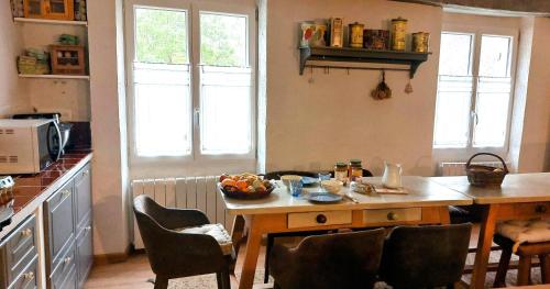 a kitchen with a table with a bowl of fruit on it at La Fischaumière in Soleilhas
