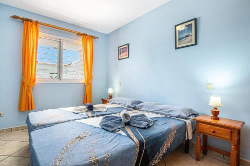 a bedroom with a bed with blue walls and a window at Apartments near the beach, with terrace and WIFI in Costa Calma
