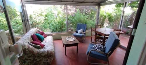 a screened in porch with a couch and a table at Maison de ville avec jardin in Thuir