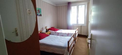 deux lits dans une petite pièce avec une fenêtre dans l'établissement Maison de ville avec jardin, à Thuir