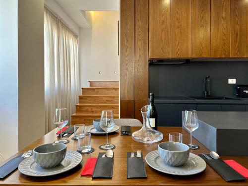 a dining room table with plates and wine glasses at SUV ApartHotel in Pogradec
