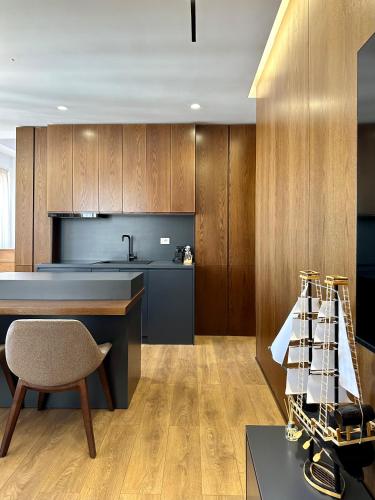 a kitchen with wooden cabinets and a table and a chair at SUV ApartHotel in Pogradec