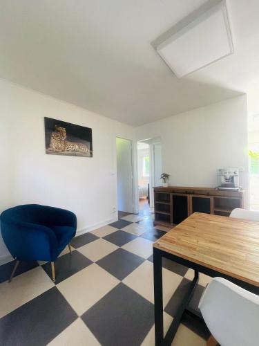 - un salon avec une table et une chaise bleue dans l'établissement Charmante petite maison, à Varengeville-sur-Mer