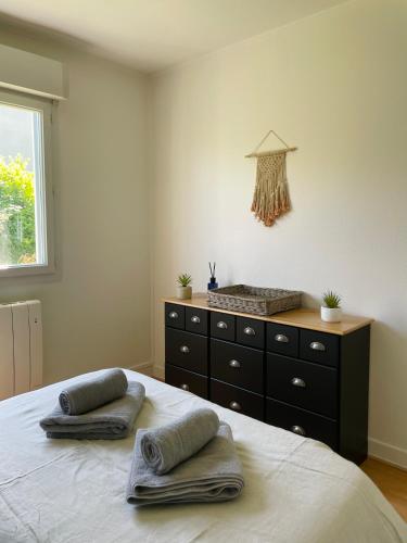 Cette chambre comprend un lit avec deux oreillers et une commode. dans l'établissement Charmante petite maison, à Varengeville-sur-Mer