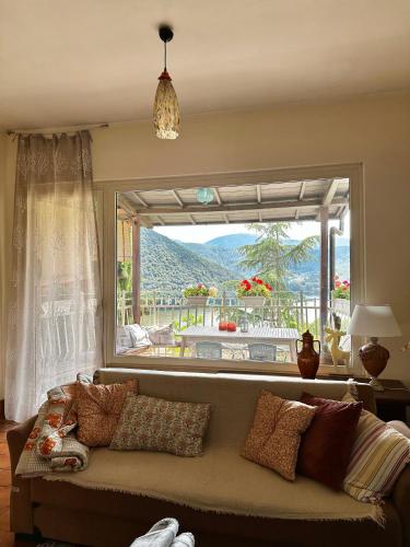 a living room with a couch and a large window at Villa bianca in Piediluco