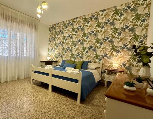 ein Schlafzimmer mit einem Bett und einer Tapete mit Palmen in der Unterkunft Dimora Sammartino in Alliste