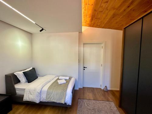 a small bedroom with a bed and a door at SUV ApartHotel in Pogradec