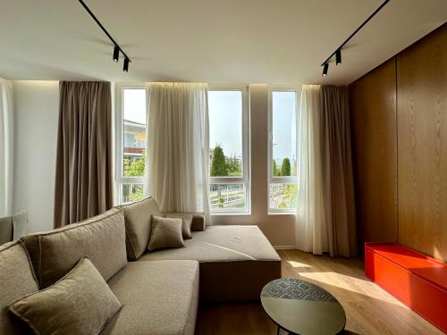 a living room with a couch and two windows at SUV ApartHotel in Pogradec
