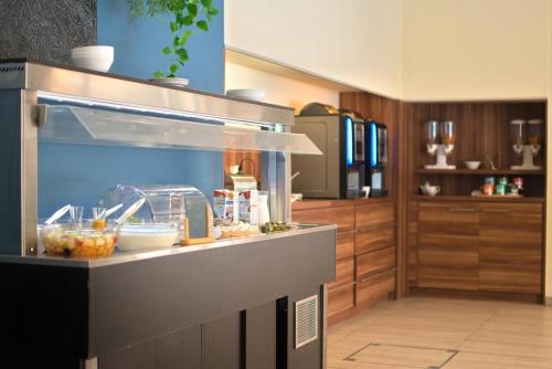 a kitchen with a counter with food on it at Kyriad Prestige Mulhouse - Basel in Sausheim