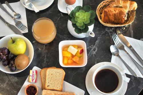 a table with breakfast foods and a cup of coffee at Kyriad Prestige Mulhouse - Basel in Sausheim