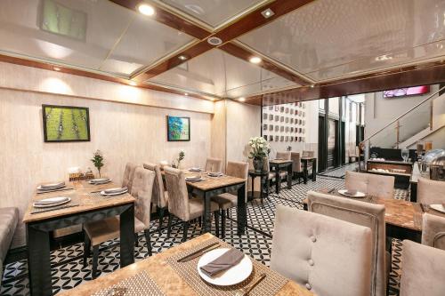 a restaurant with tables and chairs in a room at Ja Cosmo Hotel and Spa in Hanoi