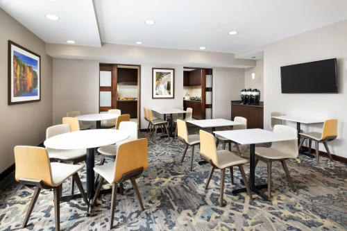 a conference room with tables and chairs and a flat screen tv at Residence Inn Concord in Concord