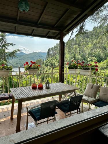 a wooden table and chairs on a deck with a view at Villa bianca in Piediluco
