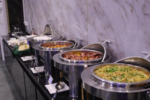 迪拜GSS Avenue Hotel Ex Delmon Hotel的一堆装满不同种类食物的托盘